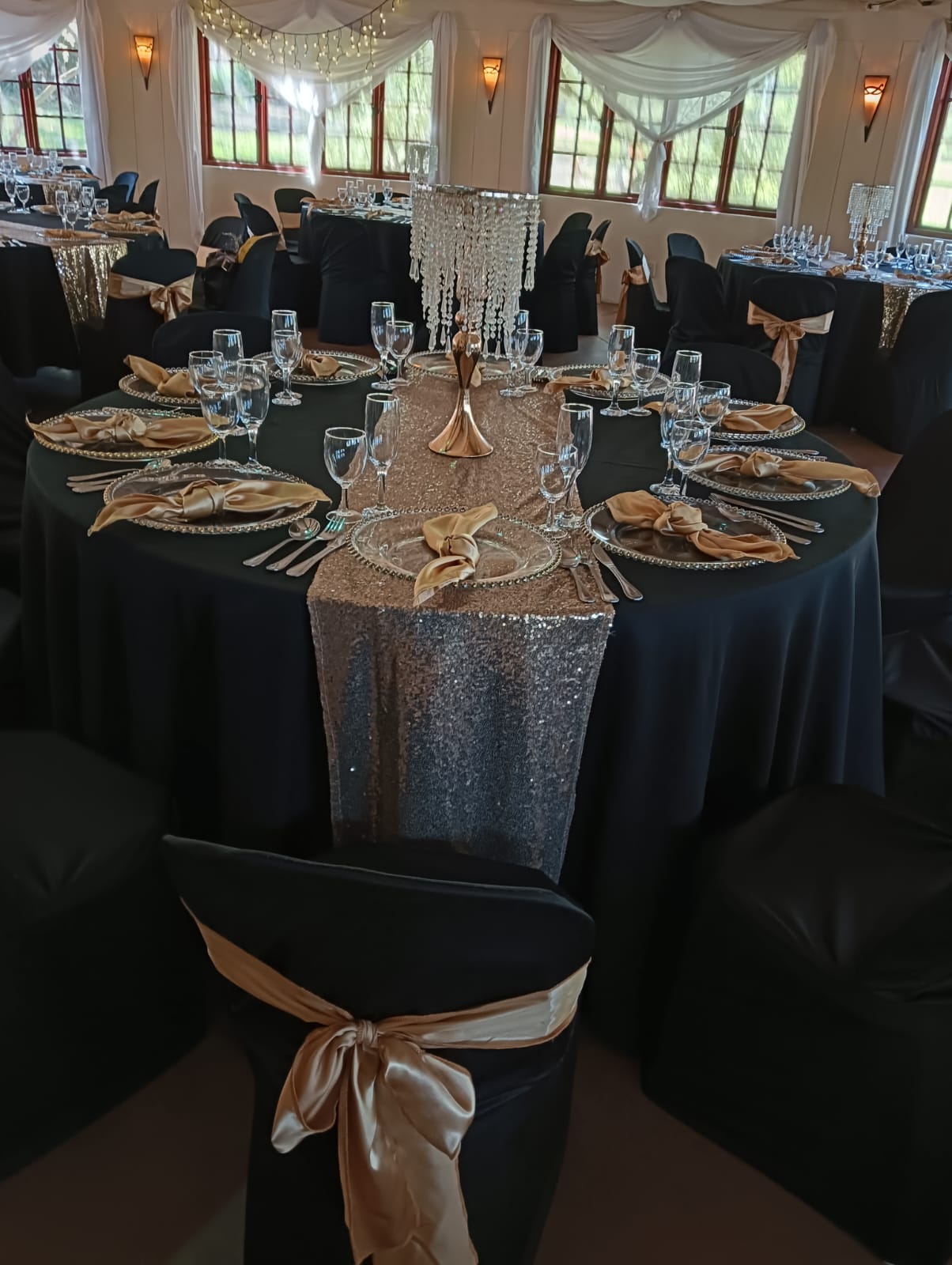 Elegant black and gold wedding reception table setting with crystal centerpiece at Mayerskraal Wedding Venue