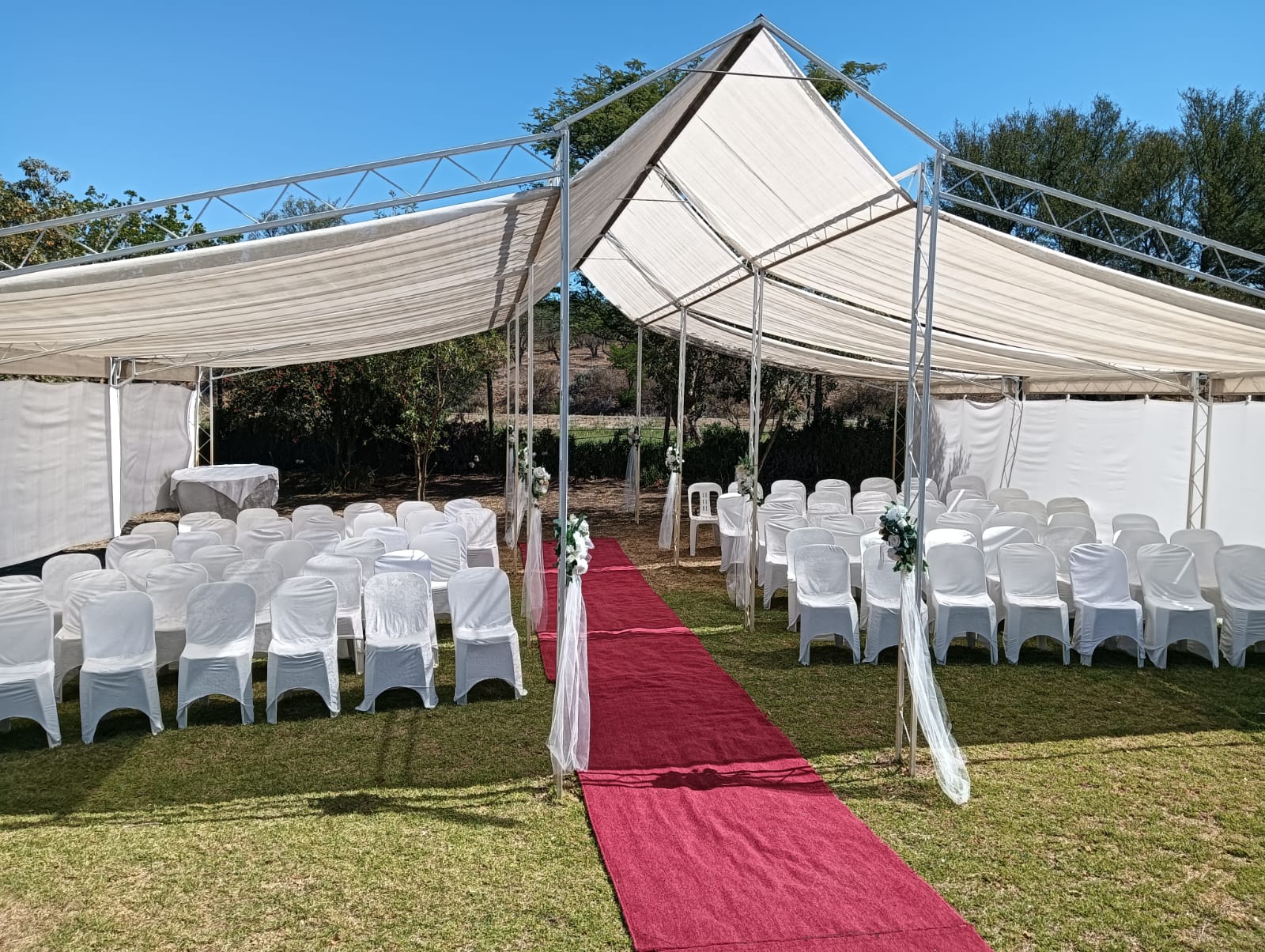 Outdoor wedding ceremony seating with a red carpet aisle at Mayerskraal Wedding Venue
