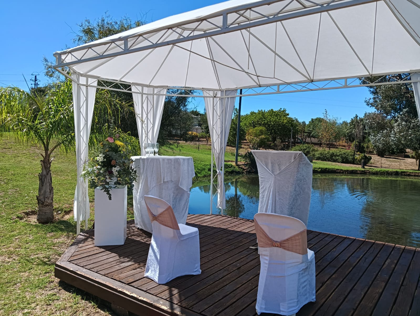 Wedding ceremony signing area with a pulpit and chairs beside the pond at Mayerskraal Wedding Venue